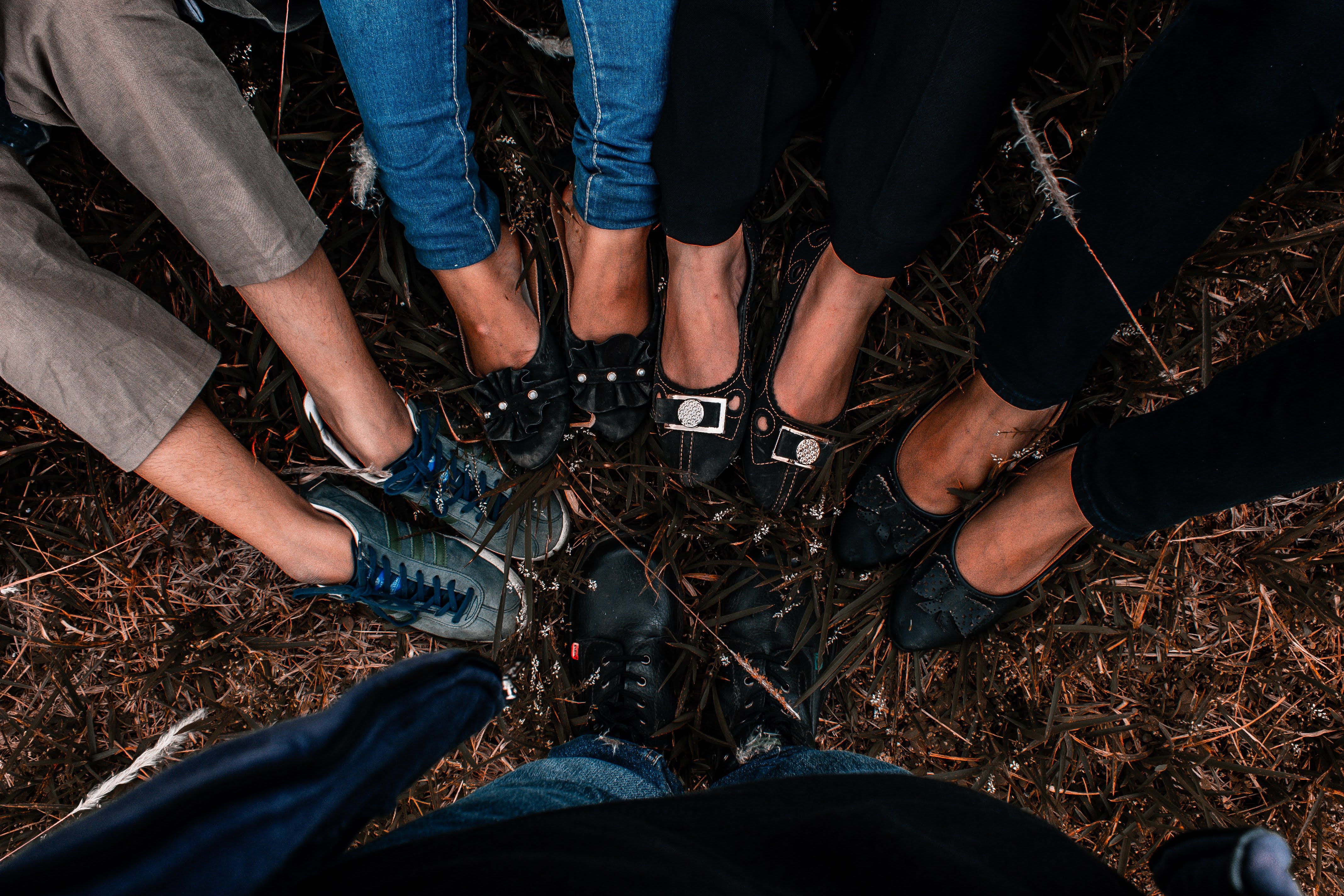 A diverse group of women standing together in a circle, feet planted side by side, ready to rise together